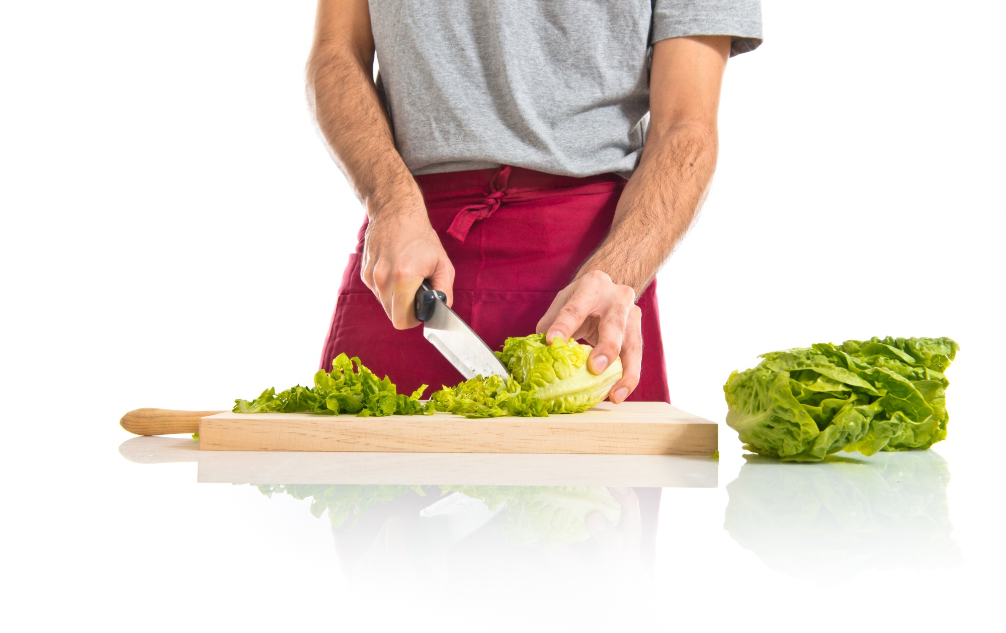 Hands slicing vegetables with chef knife